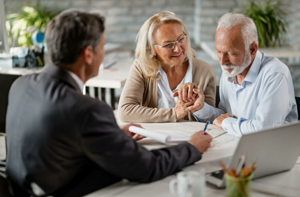 A senior couple works with a financial advisor to discuss medicare coverage