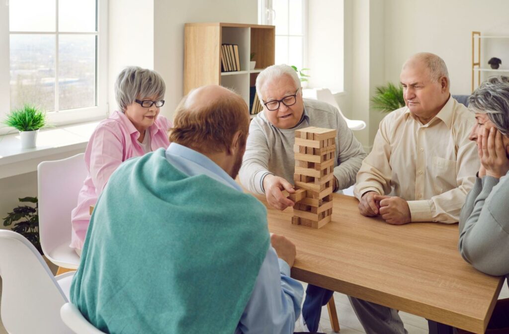 seniors sit around a table playing jenga