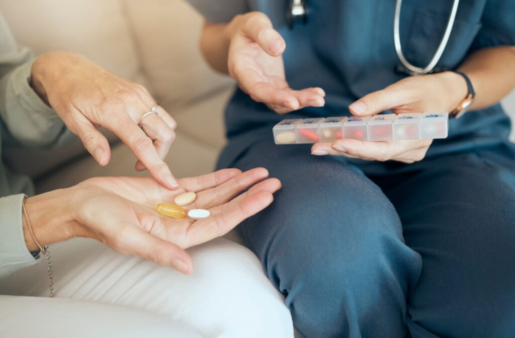 A senior living caregiver assists a resident with taking their correct daily medication.